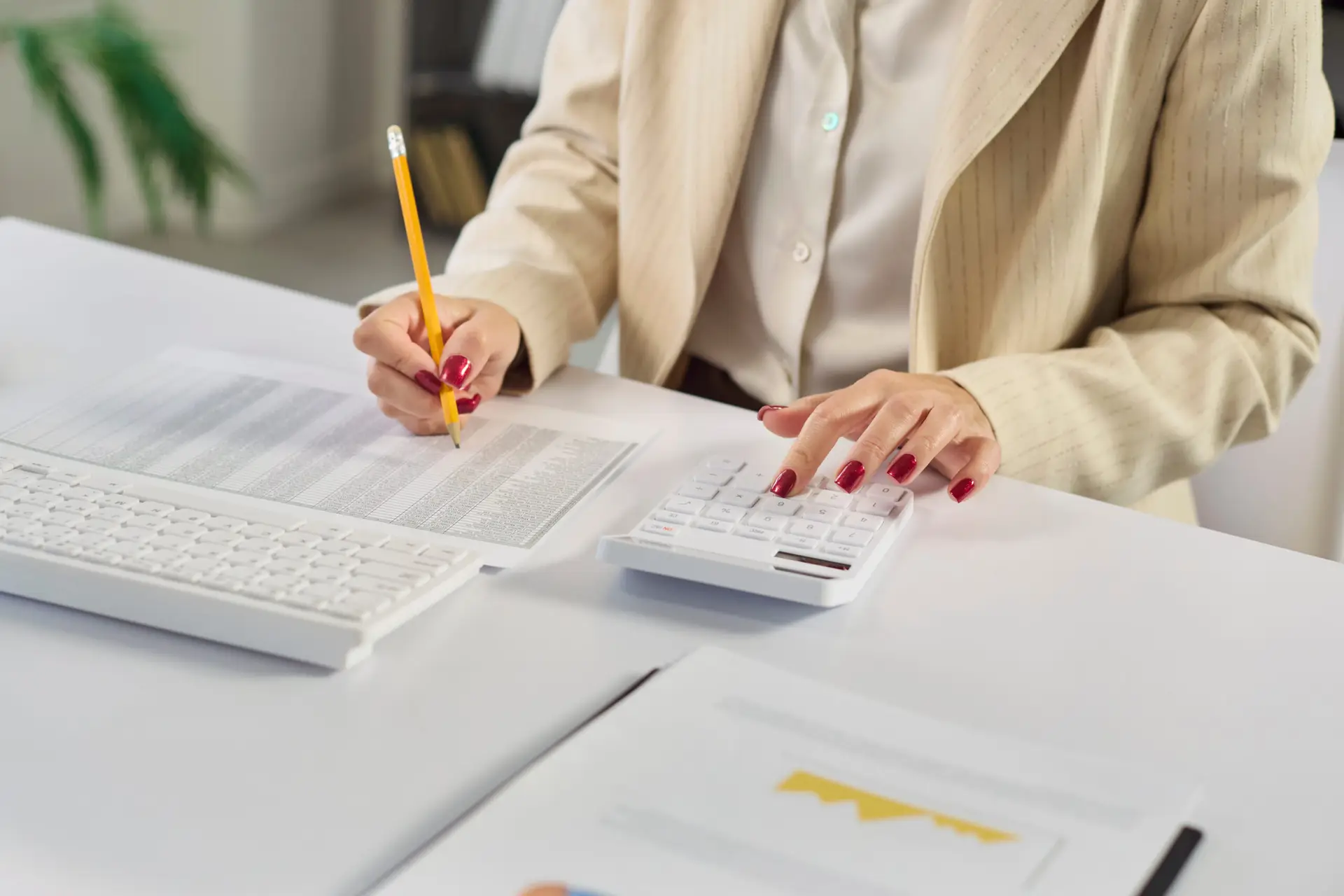 Female accountant auditing finance data with calculator in modern office